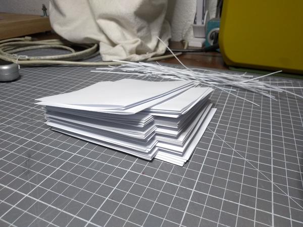 A stack of folded A5-ish sized paper, stacked in groups of 4.