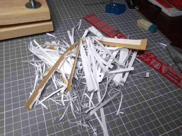 A small pile of trash, paper and some cork, that was cut off the notebook.