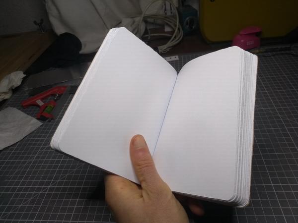 An open notebook with blank pages. The edges of the paper are visibly rough.