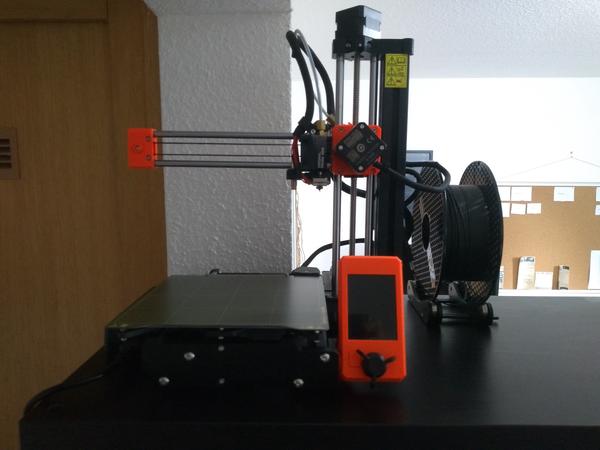 A Prusa Mini 3D printer on top of a cabinet.