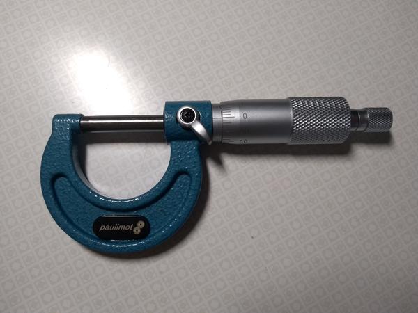 A micrometer laying on a table.