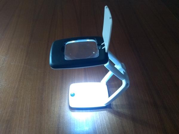 A small desktop lamp with integrated magnifying glass.